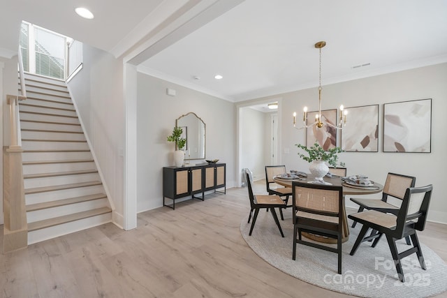 dining area with visible vents, ornamental molding, light wood finished floors, baseboards, and stairs