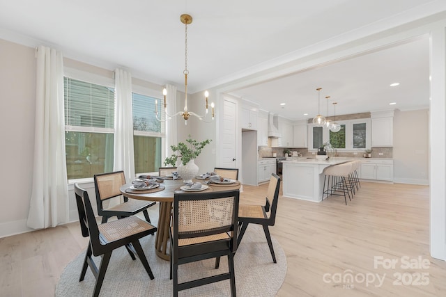 dining room with baseboards, light wood finished floors, and a chandelier