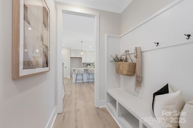 mudroom featuring baseboards and light wood finished floors