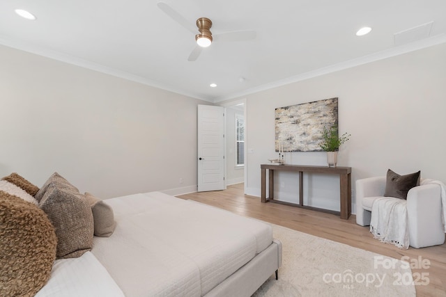 bedroom featuring light wood finished floors, recessed lighting, baseboards, and ornamental molding