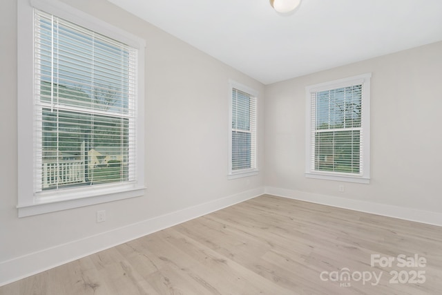 spare room with wood finished floors and baseboards