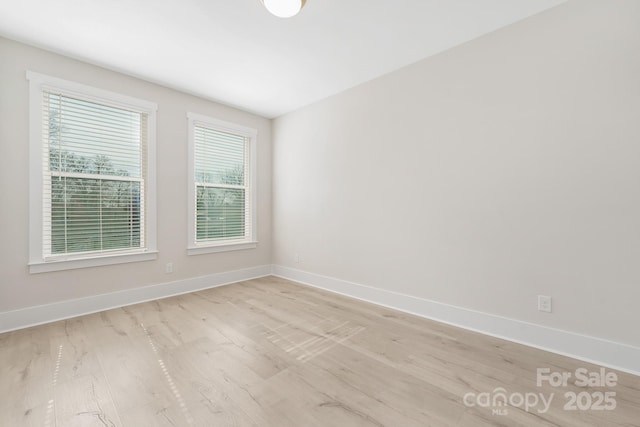 empty room featuring light wood-style flooring and baseboards