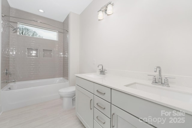 full bath featuring double vanity, toilet, washtub / shower combination, and a sink