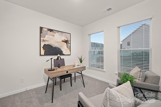 carpeted home office featuring visible vents and baseboards