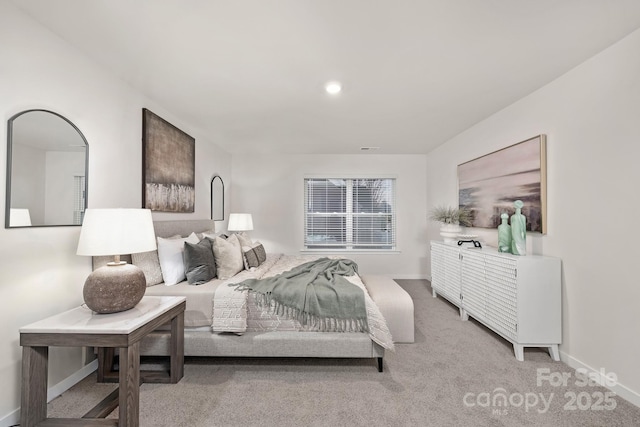 bedroom with baseboards and light carpet