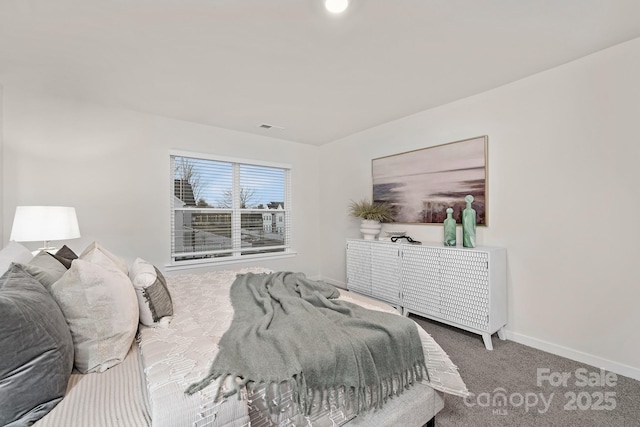 carpeted bedroom featuring visible vents and baseboards