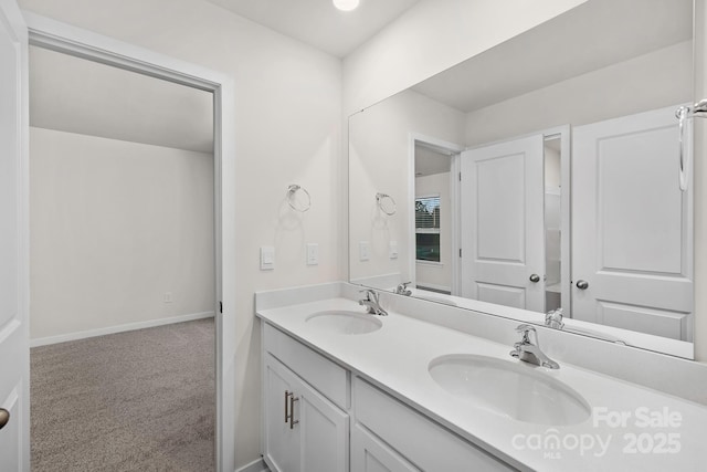 bathroom featuring double vanity, baseboards, and a sink