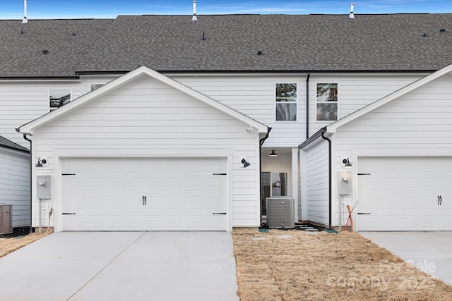 view of front facade featuring a garage, concrete driveway, and central AC