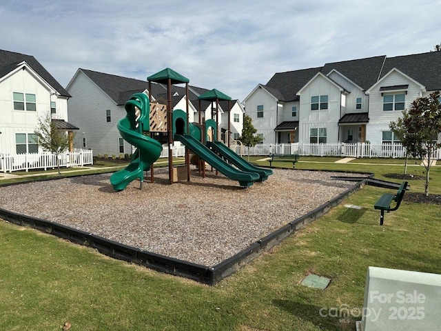 community jungle gym featuring a yard, a residential view, and fence