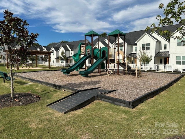 community play area featuring a residential view, a yard, and fence