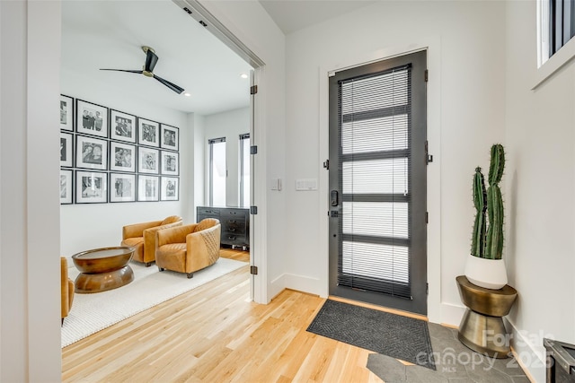 entrance foyer featuring light wood-type flooring, baseboards, and a ceiling fan