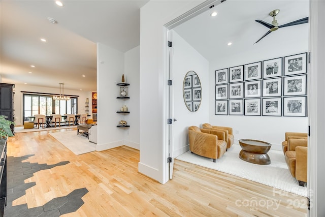 interior space with baseboards, recessed lighting, an inviting chandelier, and light wood-style floors