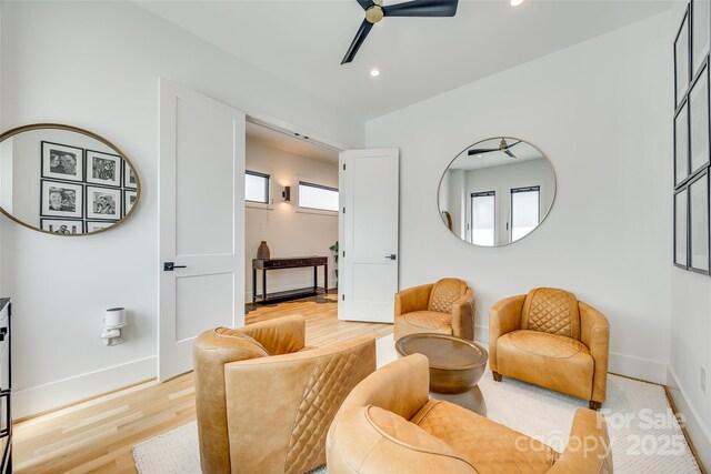living area featuring light wood-style floors, baseboards, a ceiling fan, and recessed lighting