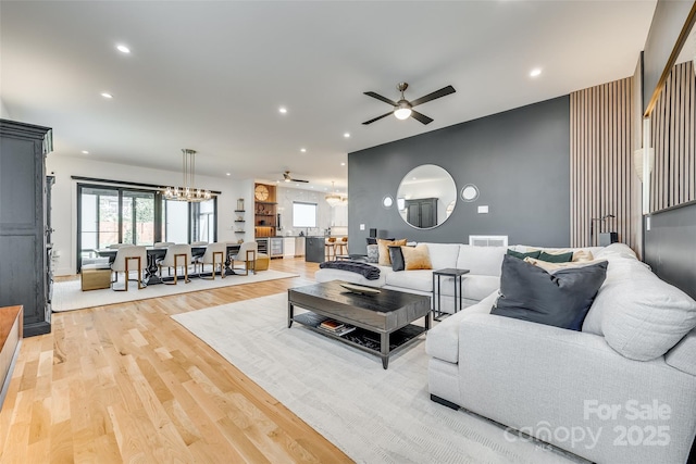 living area with light wood-type flooring, a healthy amount of sunlight, a ceiling fan, and visible vents