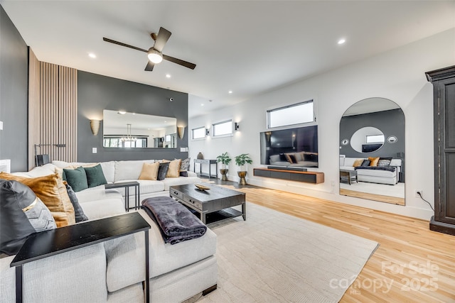 living room with baseboards, recessed lighting, a ceiling fan, arched walkways, and wood finished floors
