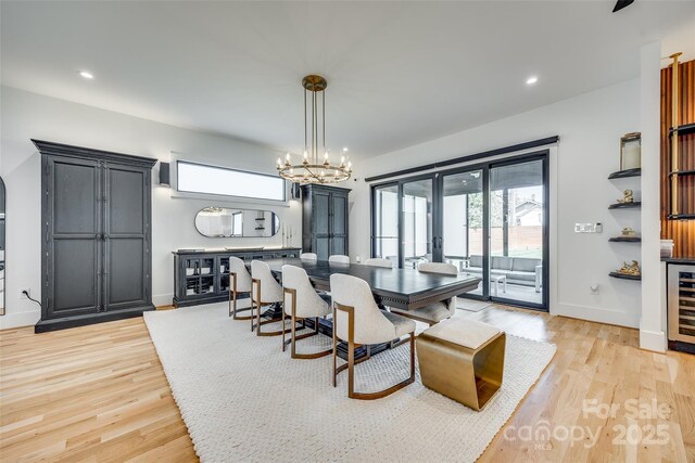 dining room featuring a chandelier, light wood-type flooring, baseboards, and recessed lighting
