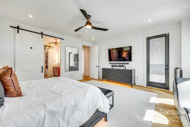 bedroom featuring visible vents, a barn door, recessed lighting, wood finished floors, and access to outside