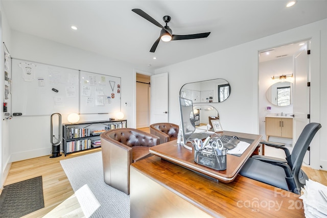 office space featuring light wood-style floors, ceiling fan, a sink, and recessed lighting