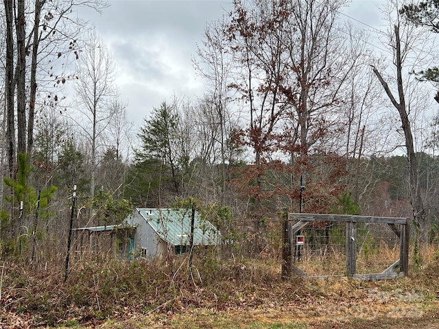 view of yard featuring a carport and a wooded view