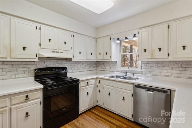 kitchen with under cabinet range hood, a sink, stainless steel dishwasher, black / electric stove, and light countertops