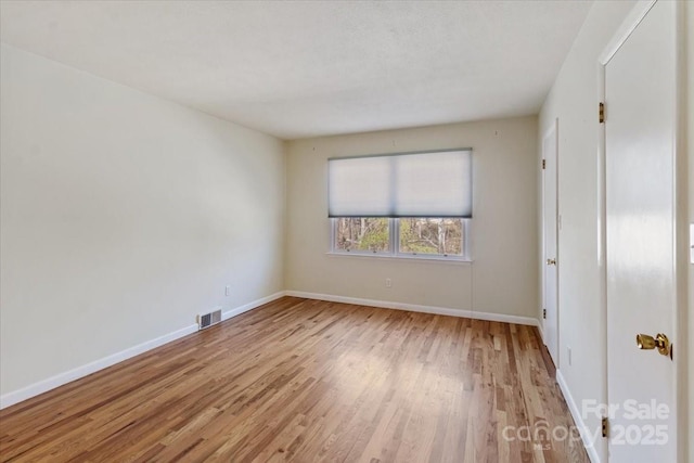 unfurnished bedroom featuring visible vents, baseboards, and wood finished floors