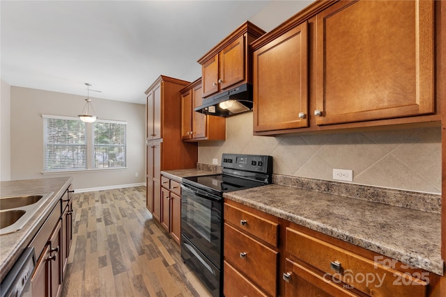 kitchen featuring black electric range oven, dishwashing machine, dark wood-style floors, under cabinet range hood, and brown cabinetry
