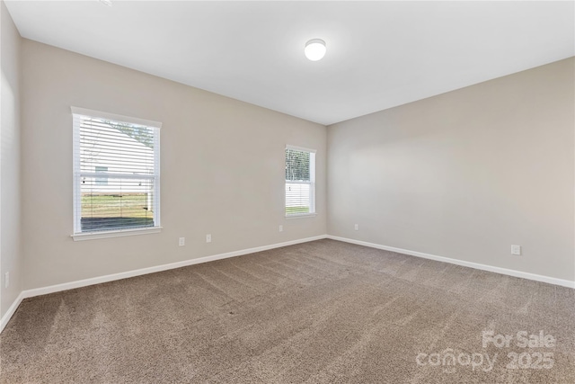 carpeted spare room with baseboards