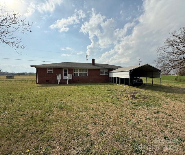 back of house with entry steps, a yard, crawl space, a carport, and brick siding
