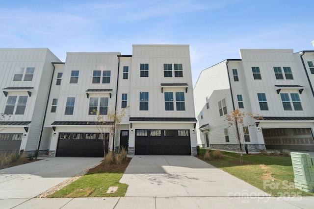 townhome / multi-family property featuring board and batten siding, metal roof, a garage, driveway, and a standing seam roof