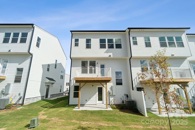 rear view of house featuring central air condition unit, a lawn, and a patio area