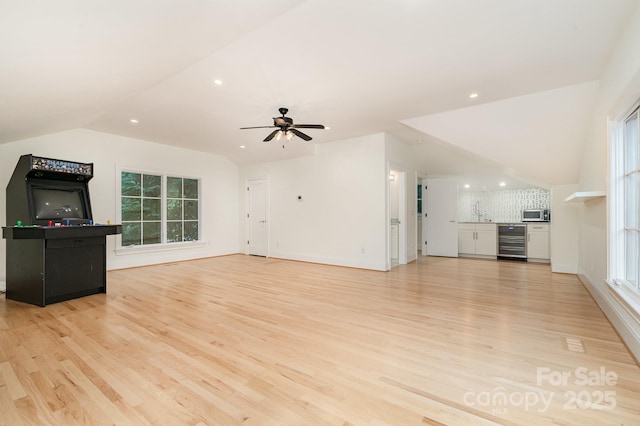 1665 Sterling Rd, Charlotte, NC 28209 - unfurnished living room featuring wine cooler, vaulted ceiling, light wood finished floors, a sink, and ceiling fan