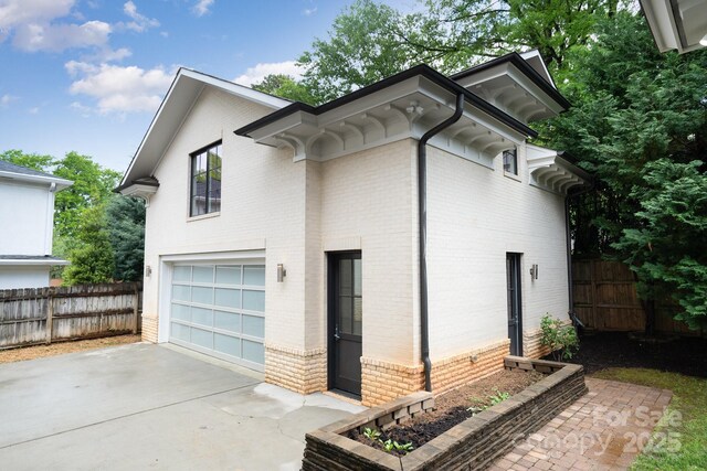 1665 Sterling Rd, Charlotte, NC 28209 - view of side of home with brick siding, a garage, and concrete driveway