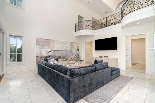 1665 Sterling Rd, Charlotte, NC 28209 - living room featuring a towering ceiling, healthy amount of natural light, baseboards, built in shelves, and ornamental molding