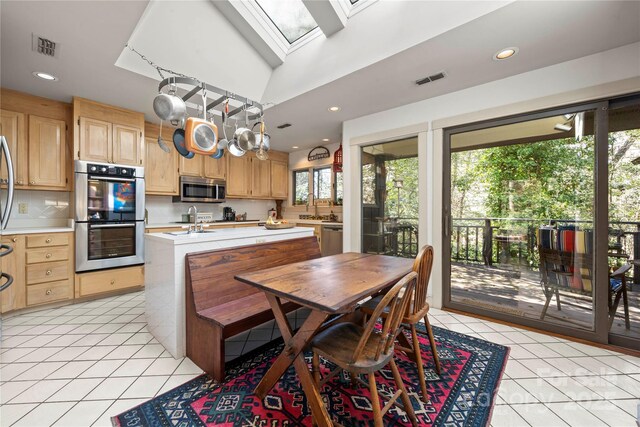 32 Fairway Rdg, Lake Wylie, SC 29710 - kitchen featuring light countertops, a skylight, light brown cabinetry, and stainless steel appliances