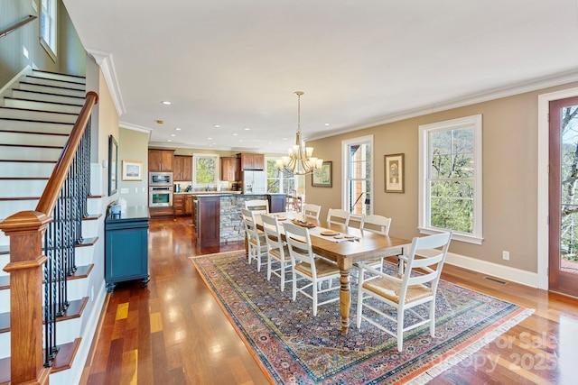 dining room featuring visible vents, ornamental molding, plenty of natural light, dark wood finished floors, and stairway