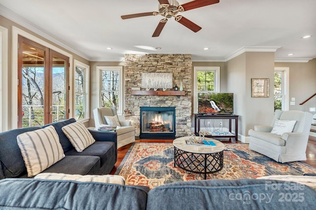 living room with a ceiling fan, a healthy amount of sunlight, wood finished floors, and crown molding