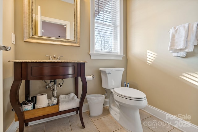 bathroom featuring tile patterned floors, toilet, and baseboards