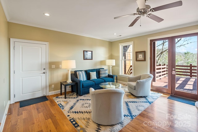 living room with ceiling fan, baseboards, light wood finished floors, and ornamental molding