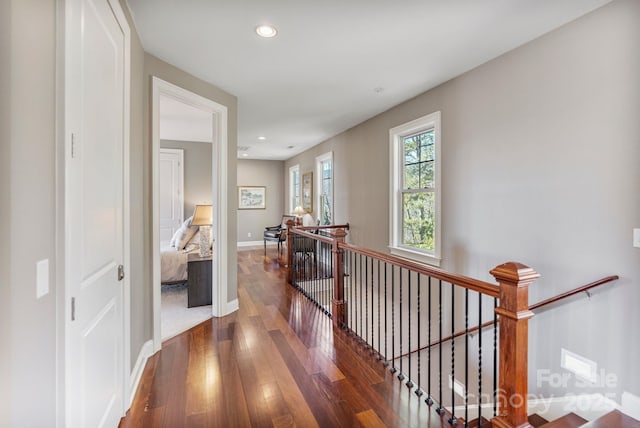 corridor featuring an upstairs landing, recessed lighting, baseboards, and wood finished floors