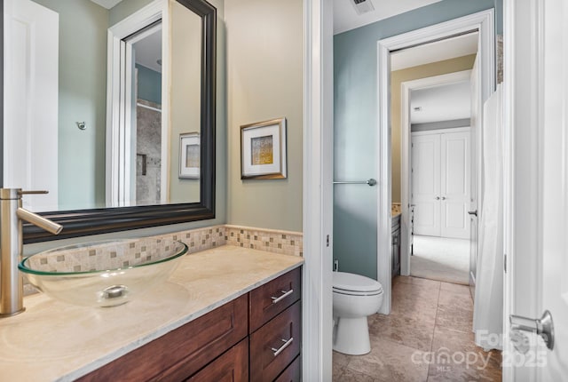 bathroom featuring decorative backsplash, toilet, vanity, and tile patterned flooring