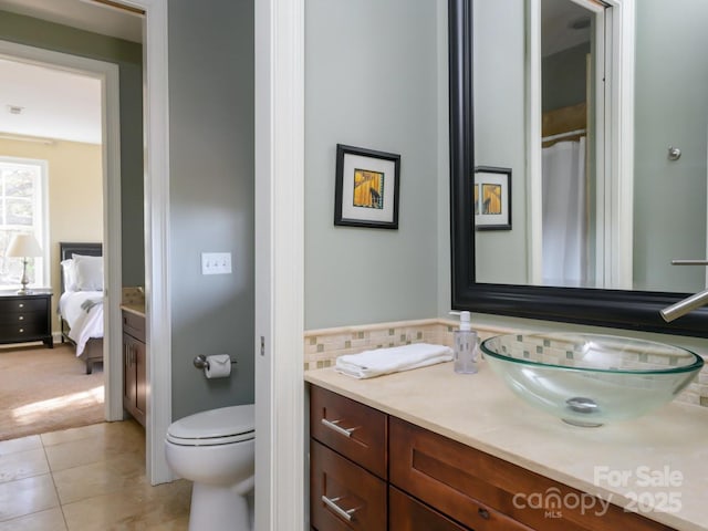 ensuite bathroom featuring tile patterned floors, toilet, vanity, and ensuite bathroom
