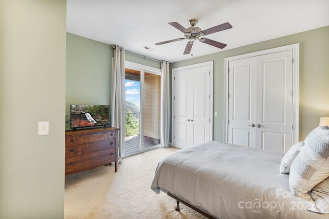 bedroom with visible vents, ceiling fan, multiple closets, access to outside, and light colored carpet