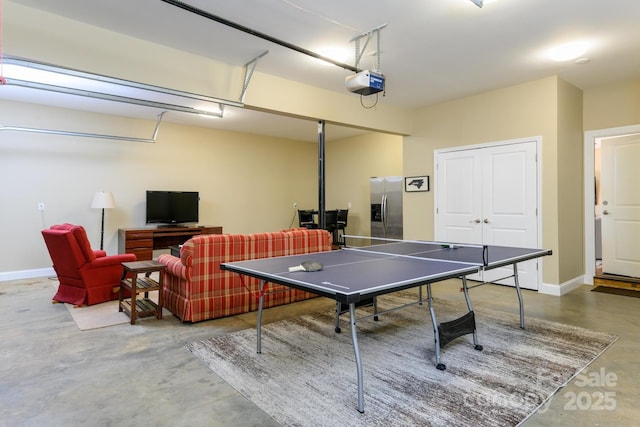 rec room with baseboards, concrete flooring, and a garage
