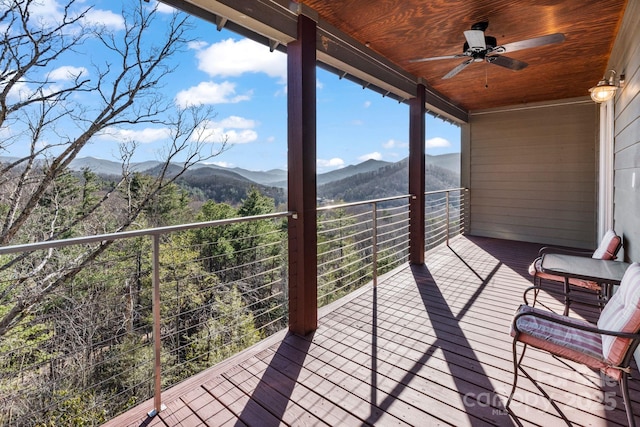 wooden deck with a ceiling fan and a mountain view