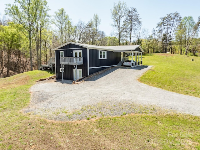 manufactured / mobile home featuring an attached carport, driveway, and a front lawn
