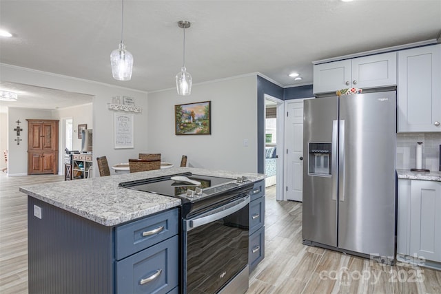 kitchen with a center island, decorative light fixtures, ornamental molding, appliances with stainless steel finishes, and light wood-style floors