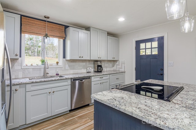 kitchen featuring appliances with stainless steel finishes, decorative backsplash, a sink, and hanging light fixtures