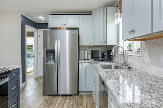 kitchen featuring a sink, tasteful backsplash, a wealth of natural light, and appliances with stainless steel finishes