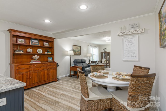 dining area featuring crown molding, baseboards, light wood-type flooring, and recessed lighting