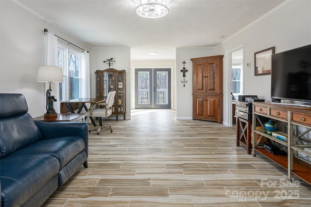 living room with crown molding, baseboards, and light wood-type flooring